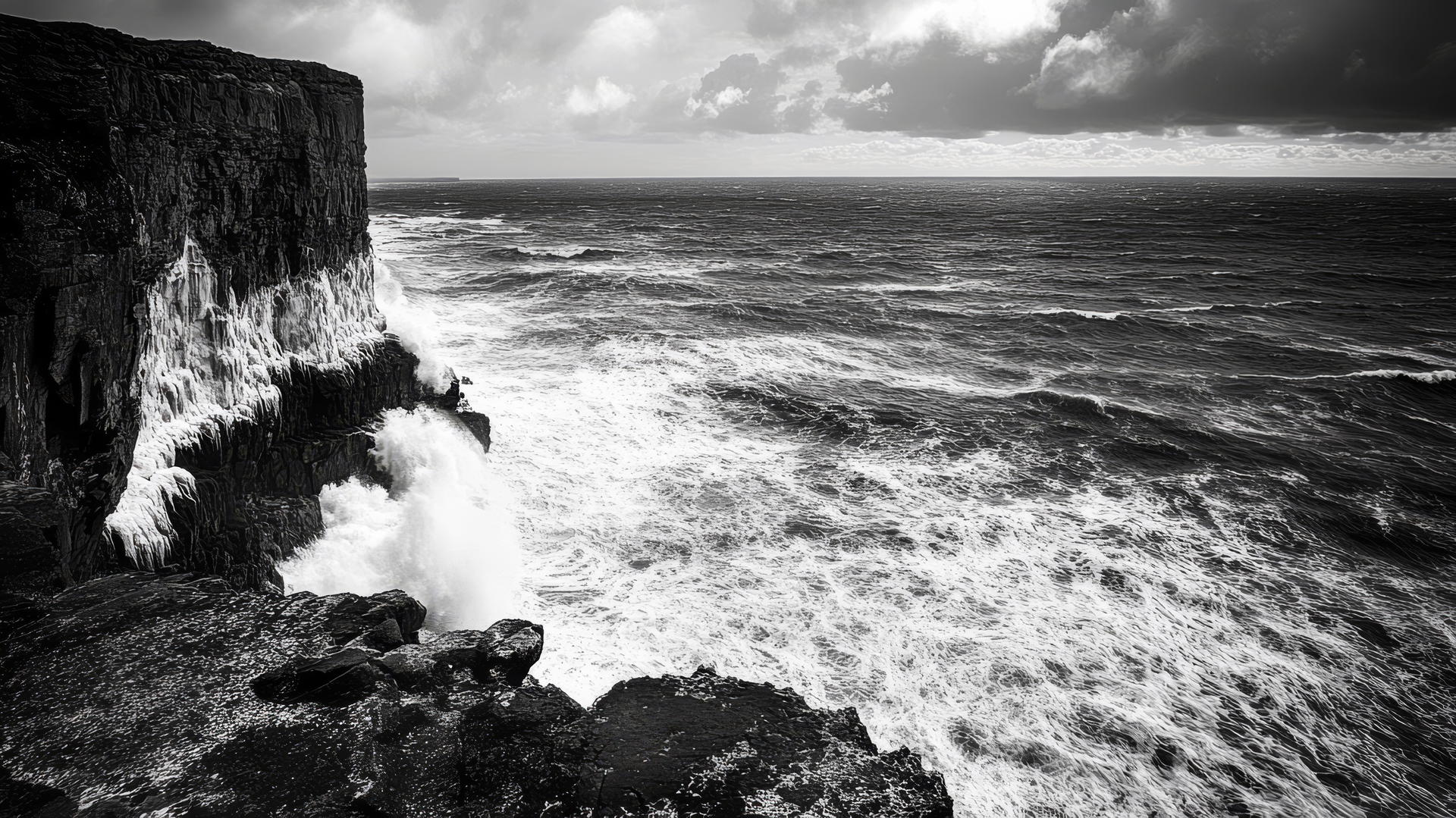 black and white wallpaper of an ocean with waves crashing against a rocky shoreline