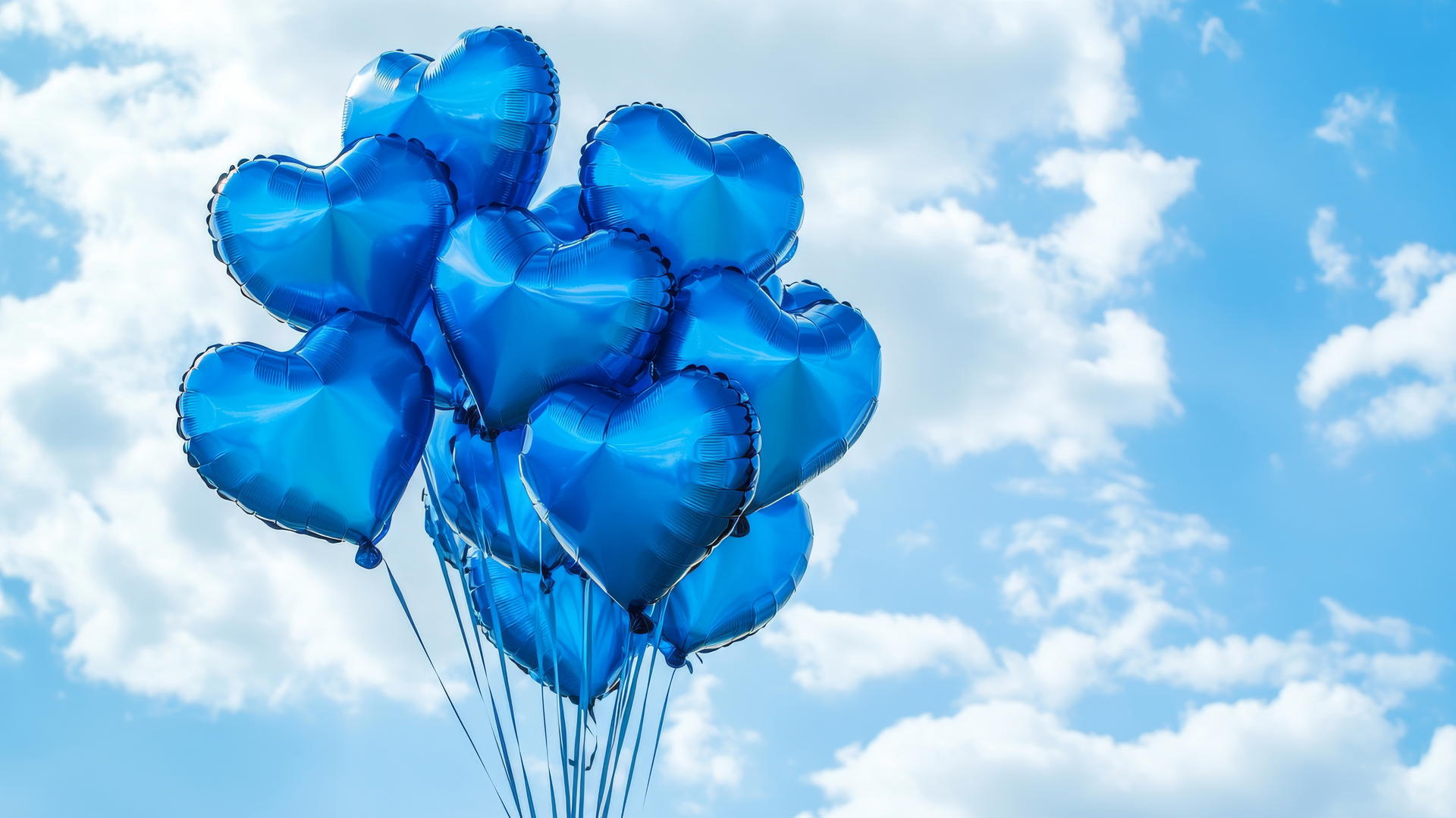 A cluster of blue heart-shaped balloons floating in a clear blue sky with fluffy white clouds, blue heart wallpaper