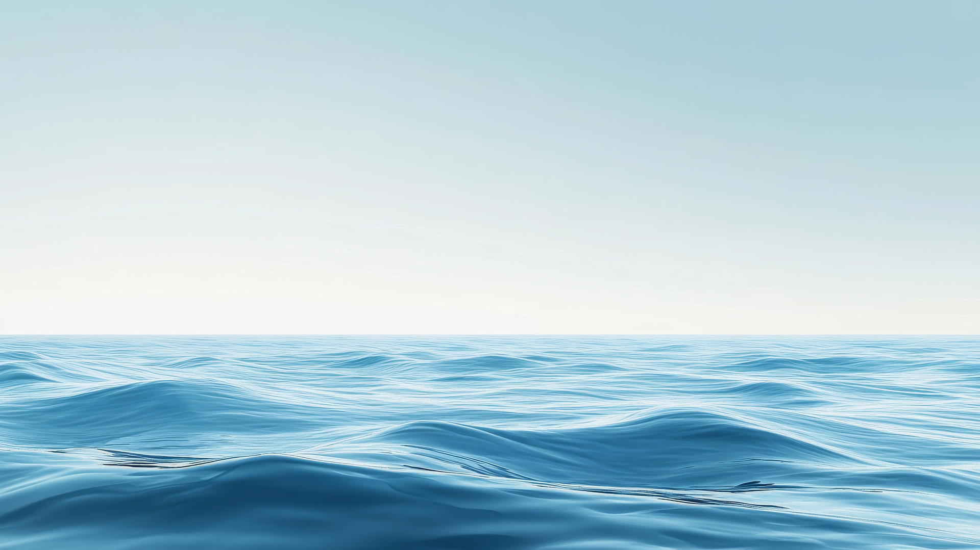 A tranquil ocean scene with gentle waves in different blue tones under a clear sky, blue wallpaper