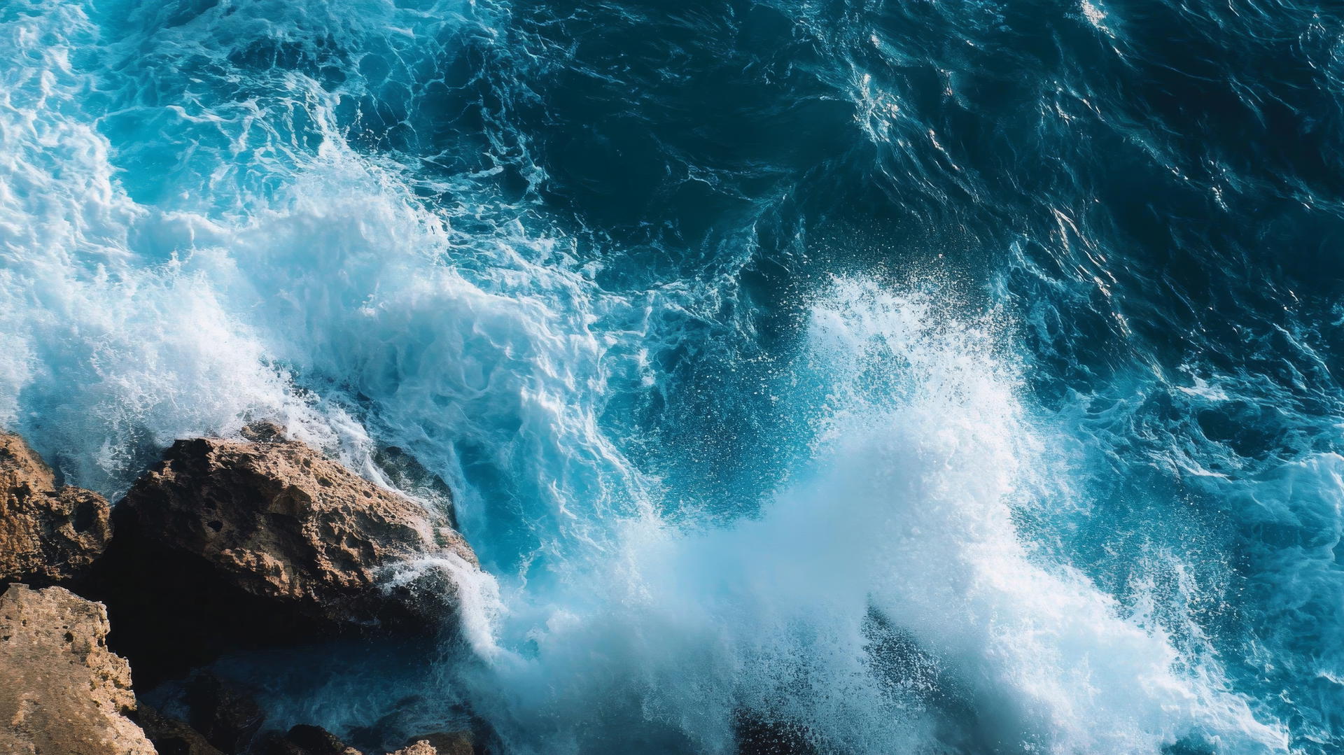 wallpaper blue with powerful ocean waves crashing against rugged rocks