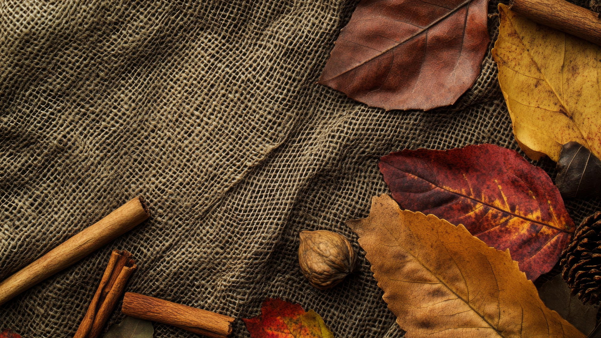 thanksgiving aesthetic wallpaper with textured burlap, linen, leather, autumn leaves, and cinnamon sticks