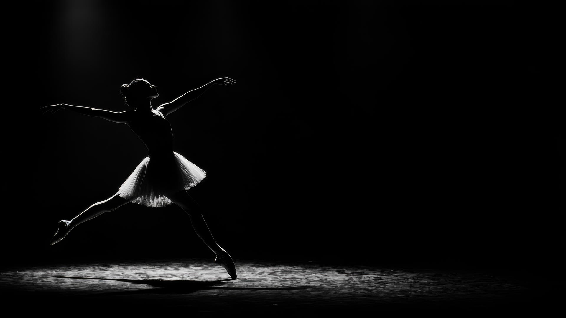 black and white wallpaper of a ballerina mid-pirouette against a dark background
