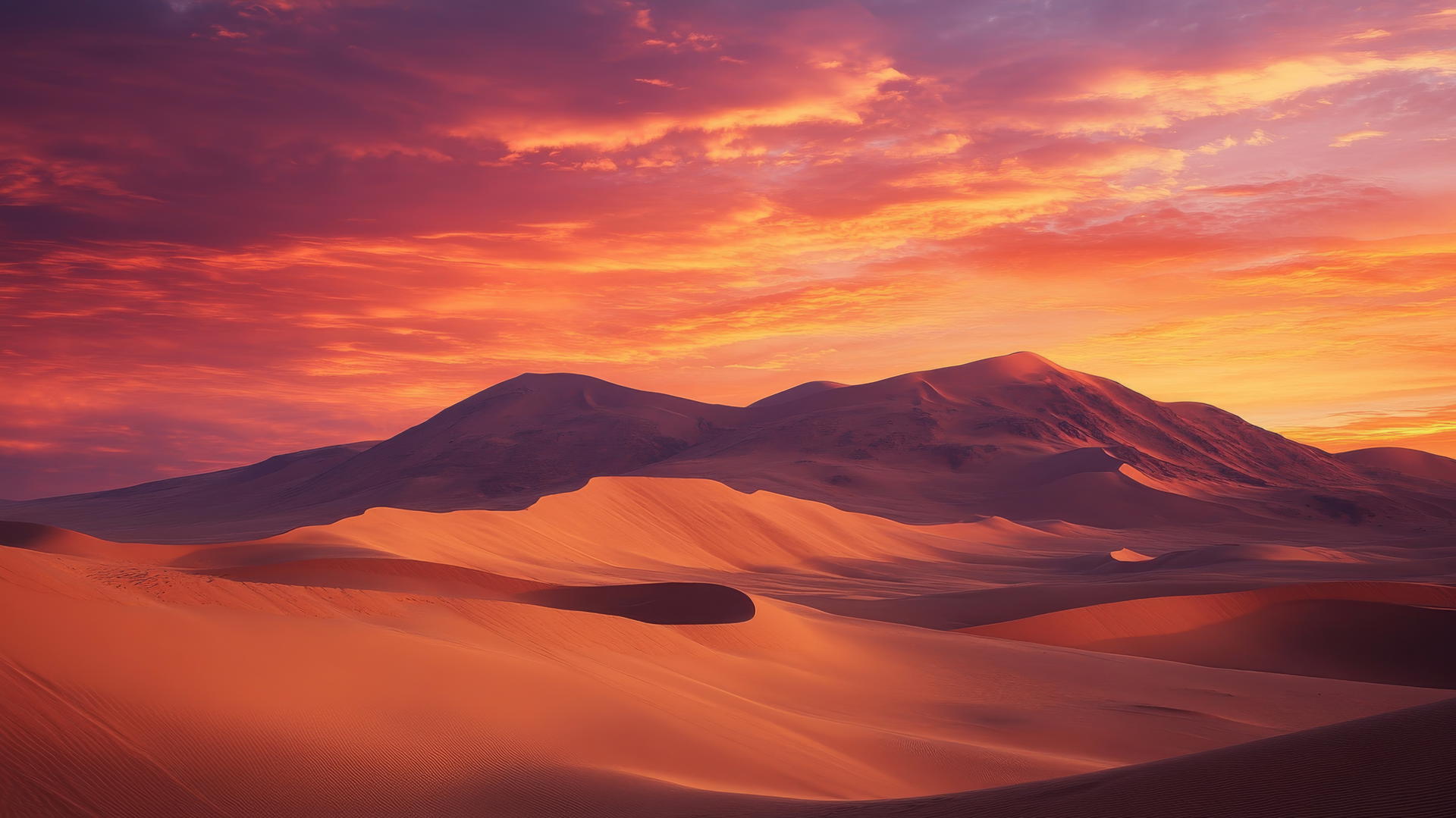 Nature wallpaper with dramatic desert landscape, towering sand dunes, under deep orange and pink sunset sky.
