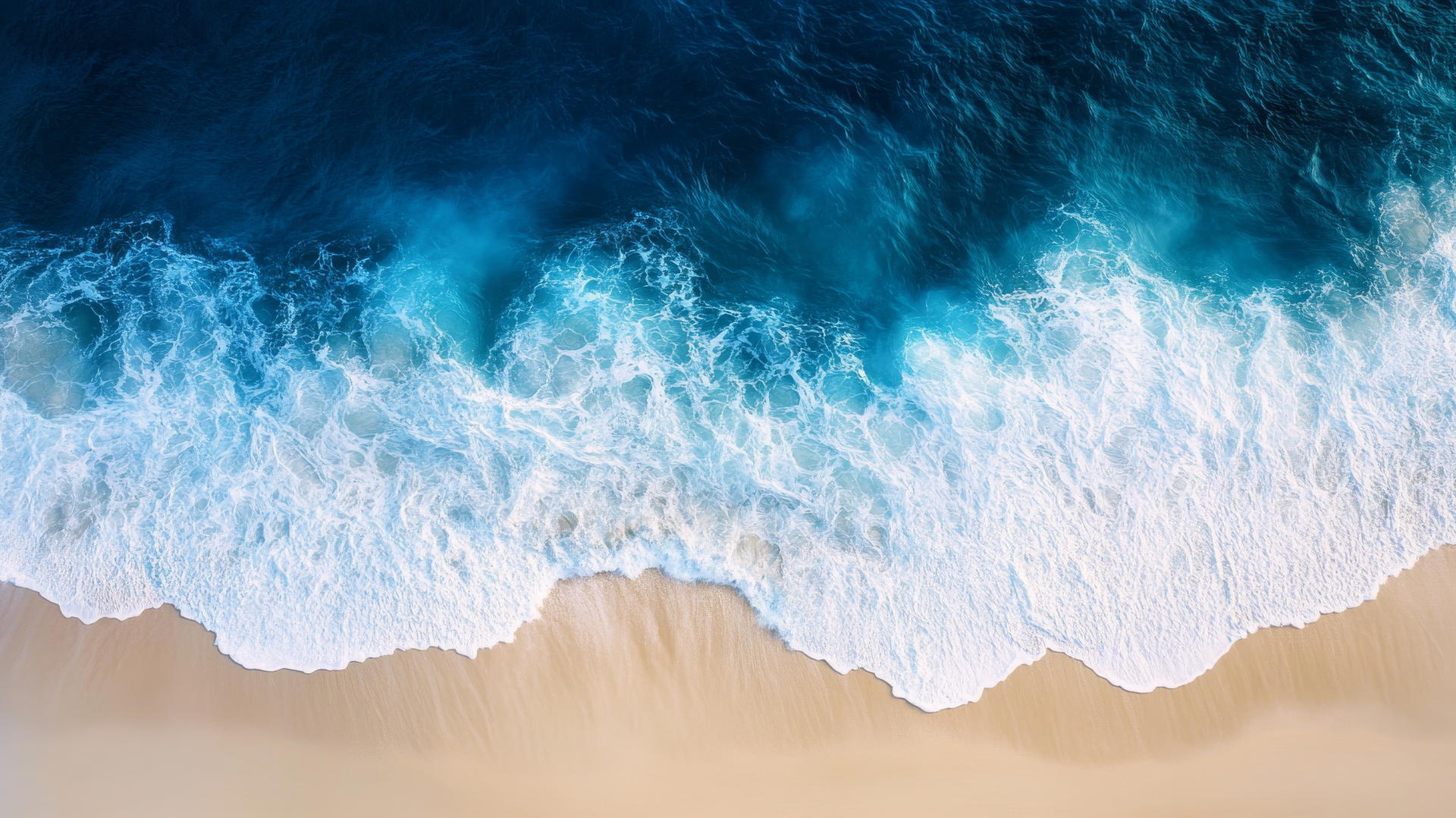 Overhead drone shot of beach. Smooth white sand and deep blue ocean waves. Beach pictures wallpaper.