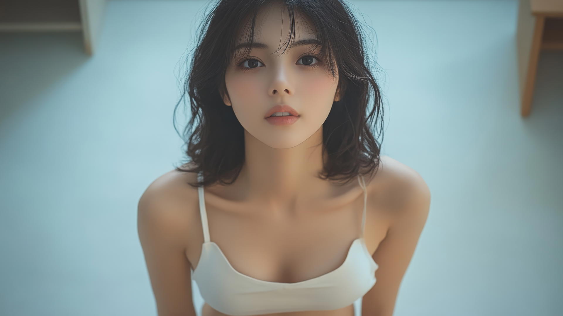 Asian girl in white shirt kneeling, smiling, seen from below