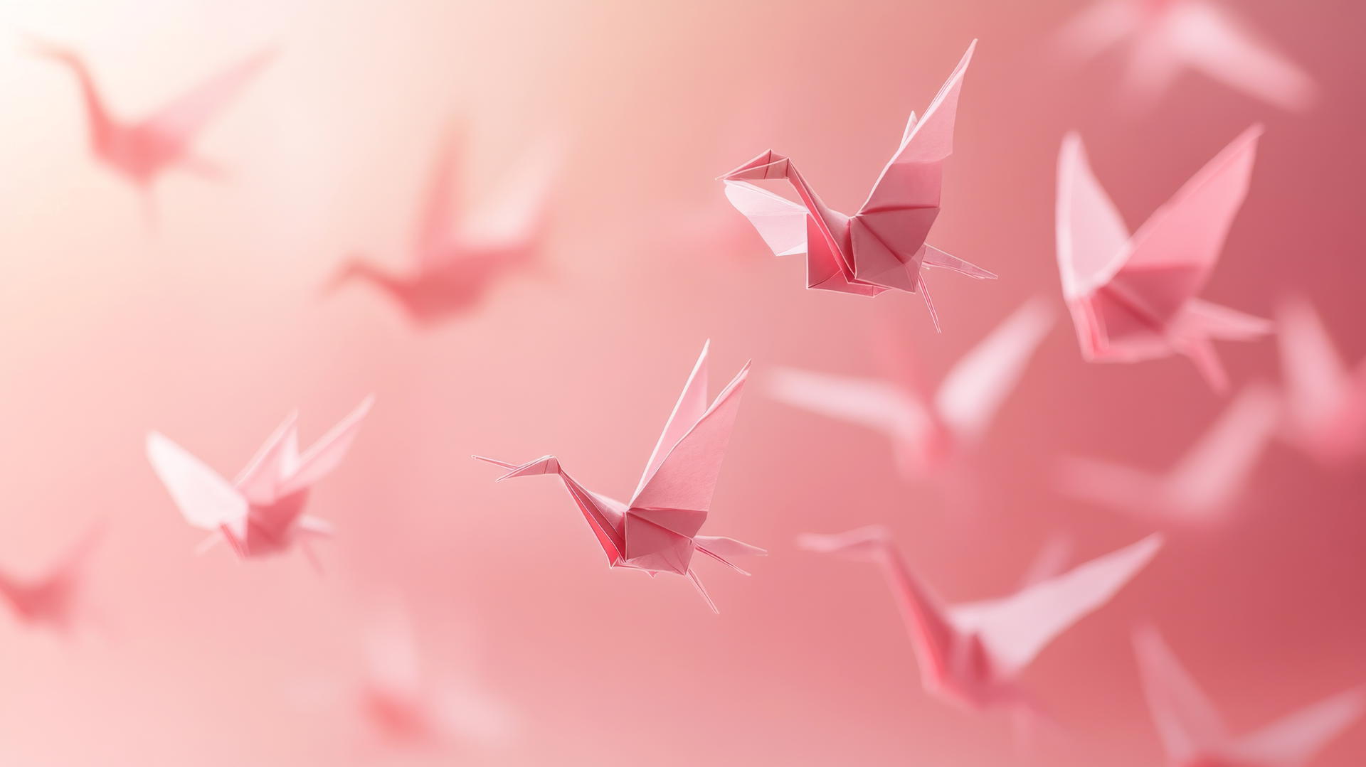 Aesthetic pink wallpaper with pink paper cranes floating mid-air.