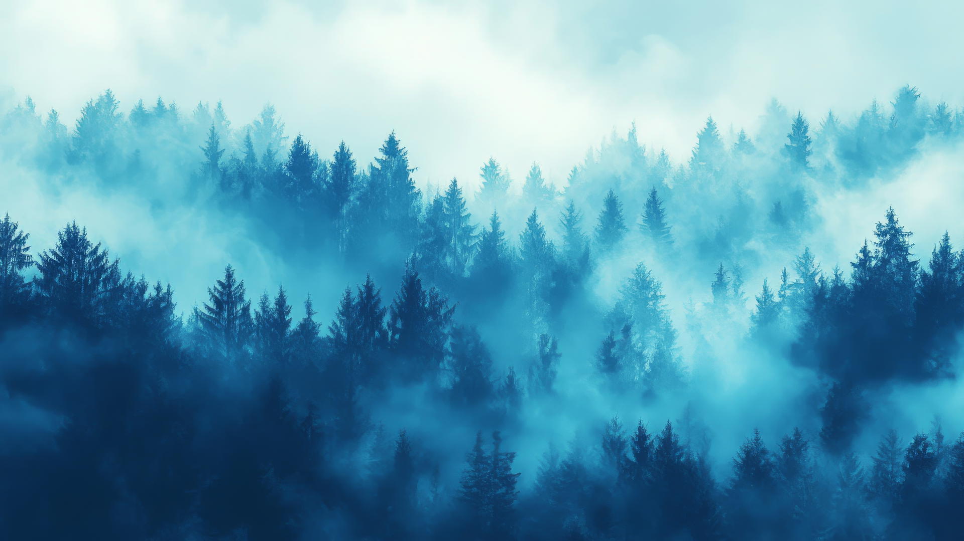 Aesthetic blue wallpaper of ethereal blue fog over a forest with light filtering through the mist