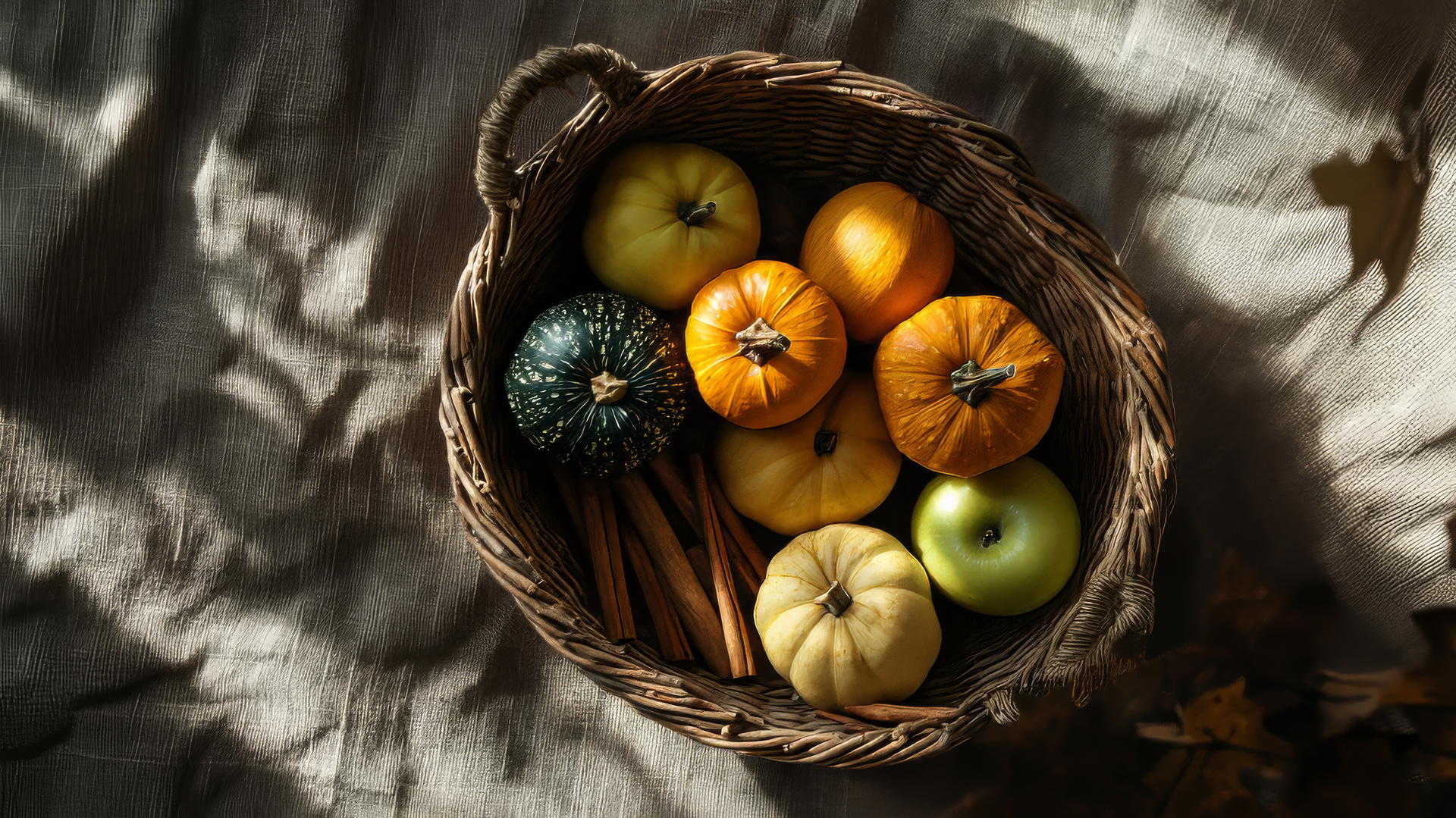 thanksgiving aesthetic wallpaper with squash, apples, cinnamon sticks in a woven basket