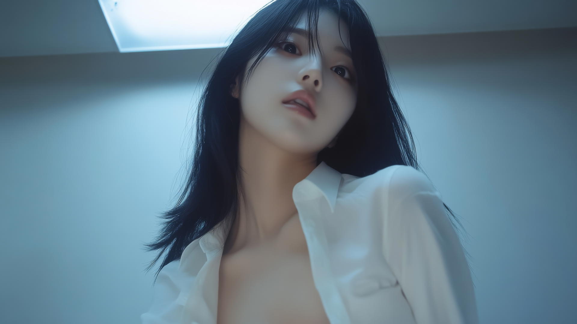 Korean pop star girl in white office shirt, seen from below, kneeling, looking down.