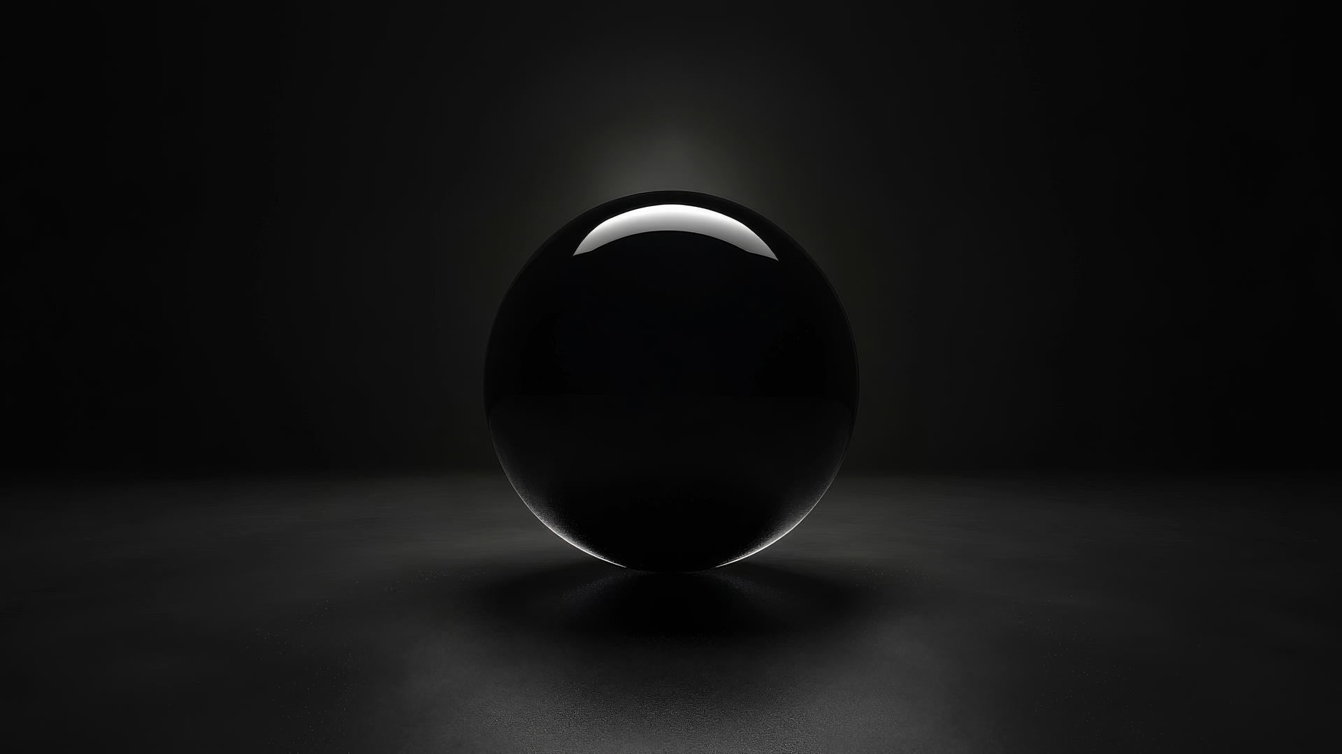 Glowing black sphere hovering in a dark space with light reflecting off edges.