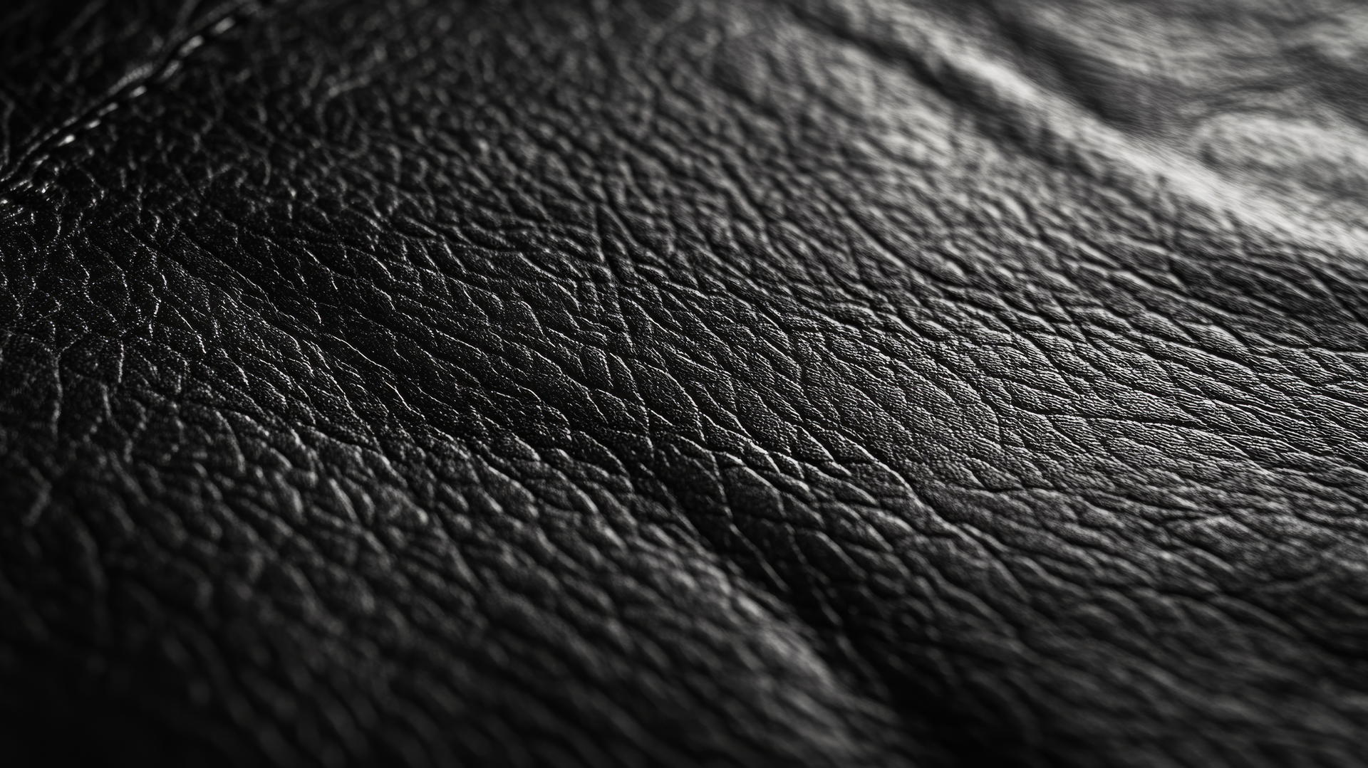 Black wallpaper aesthetic with detailed close-up of black leather texture and light reflections