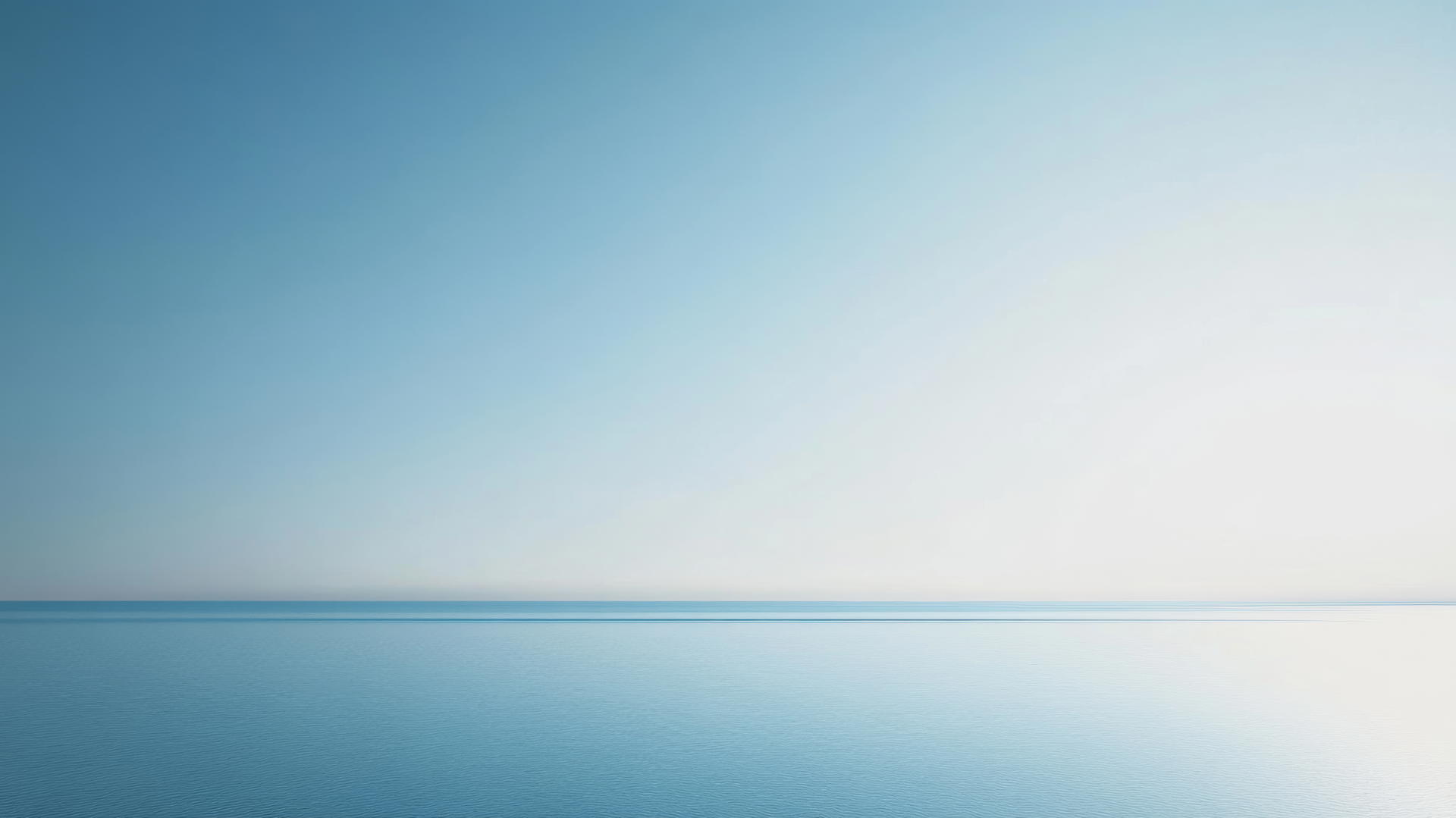 Aesthetic blue wallpaper with a minimalist blue horizon line and pale sky.