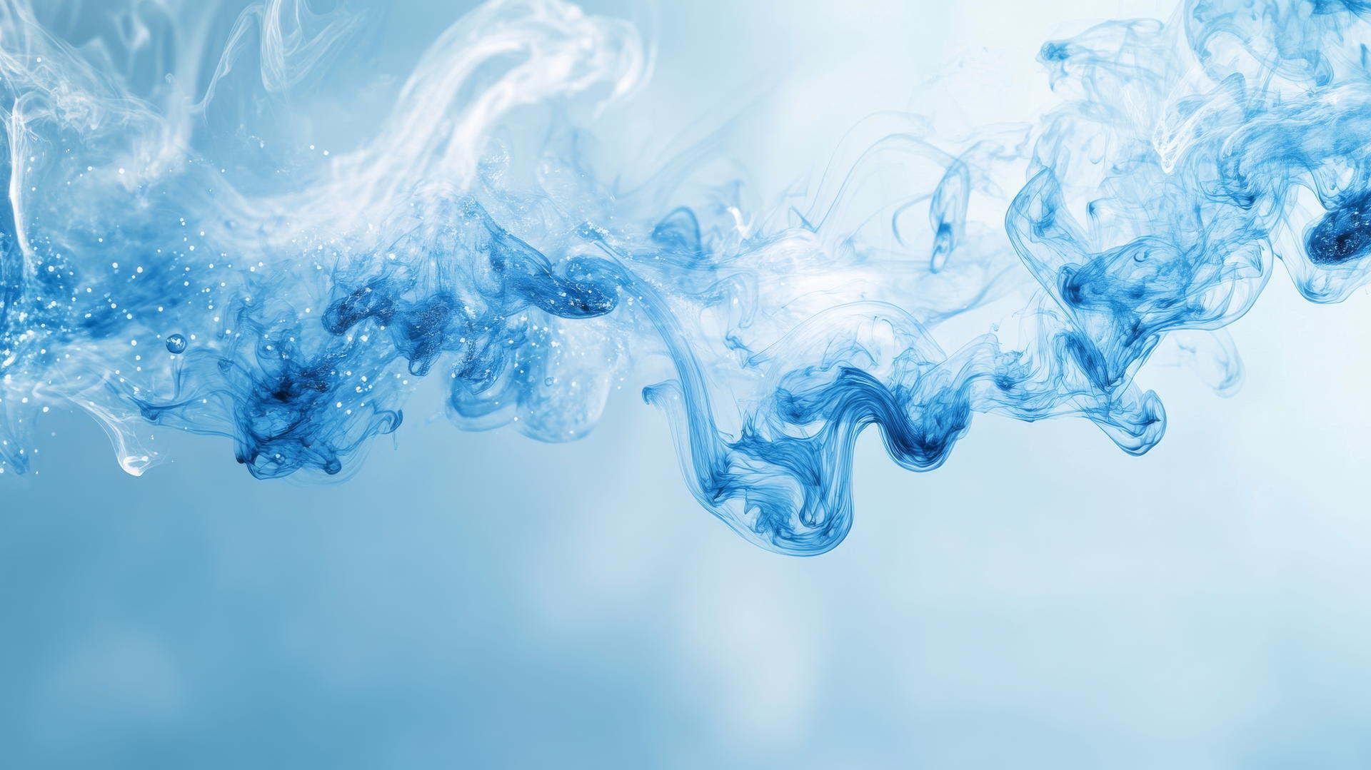 blue background wallpaper with blue ink droplets dispersing in water