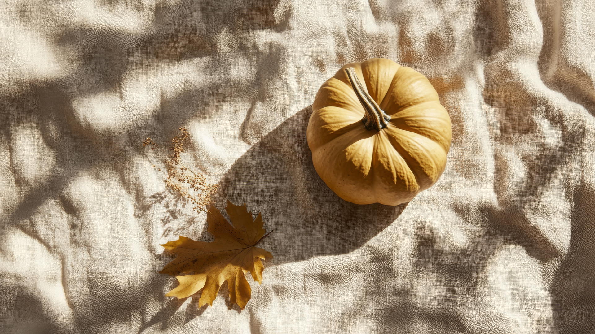thanksgiving wallpaper aesthetic featuring a golden pumpkin on a linen tablecloth