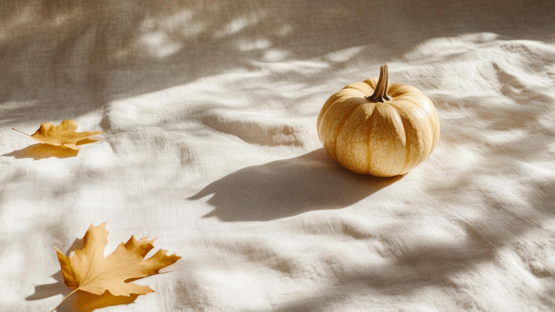thanksgiving wallpaper aesthetic with a golden pumpkin and dried leaves