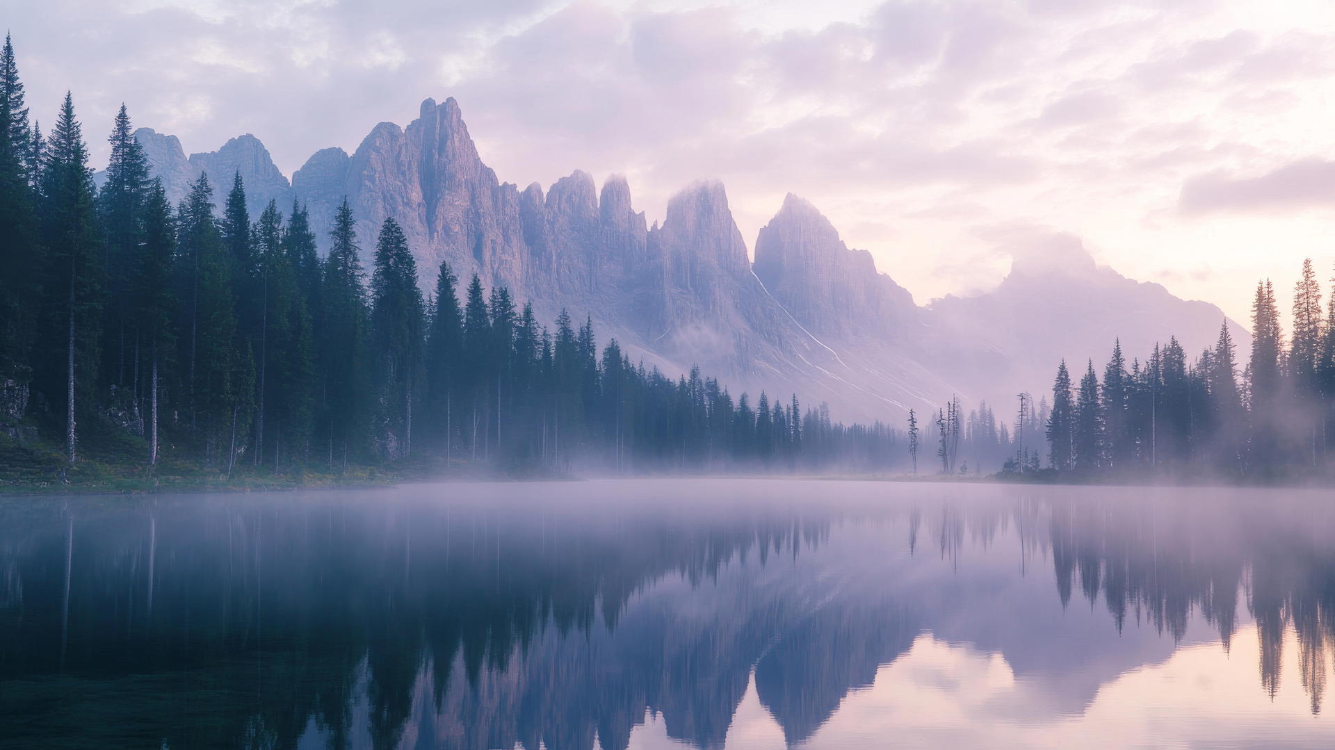 Tranquil mountain lake at dawn with mist, perfect for a summer wallpaper