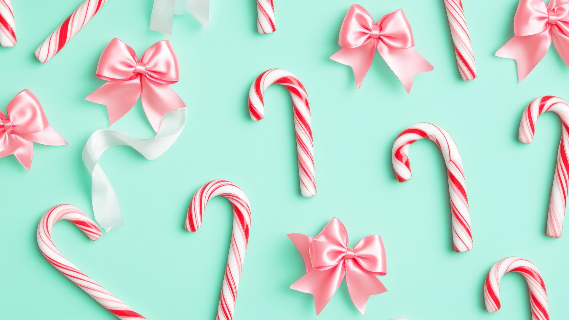 cute preppy Christmas wallpaper with red and white candy canes, pink ribbons, and mint green background