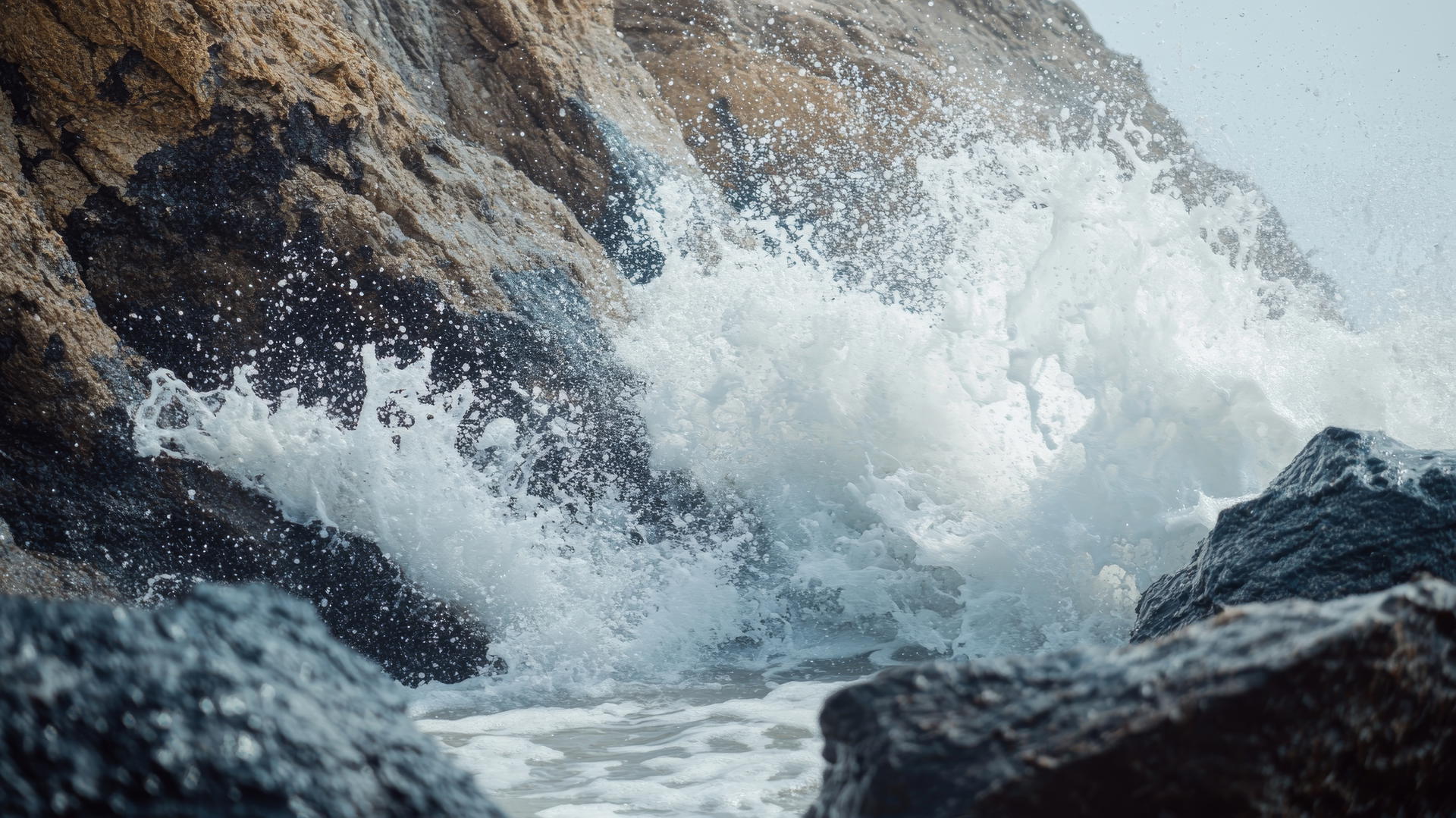 4K beach wallpaper with waves crashing against rocky formations